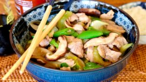 Chicken Chop Suey in Blue Ramen Bowl with chopsticks crossed at edge of bowl and hot sauce in background