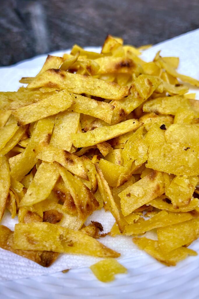 Tortilla cut into strips and gently tossed in lightly oiled black skillet. 